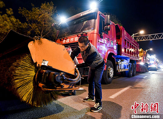 乌鲁木齐夜色中进行冬季城市道路积雪清运应急演练