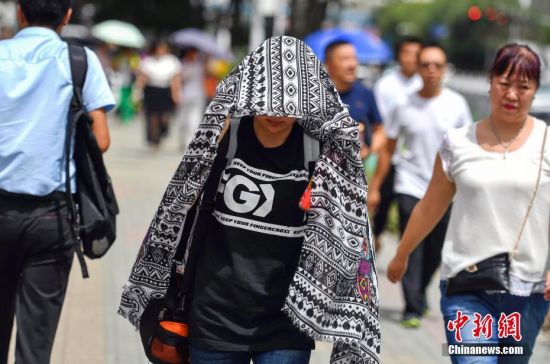 新疆乌鲁木齐高温达36摄氏度 民众顶烈日出行